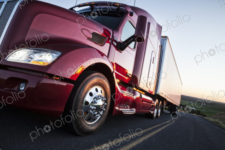 Front to rear low angle view of the cab of a commercial truck on the highway late in…