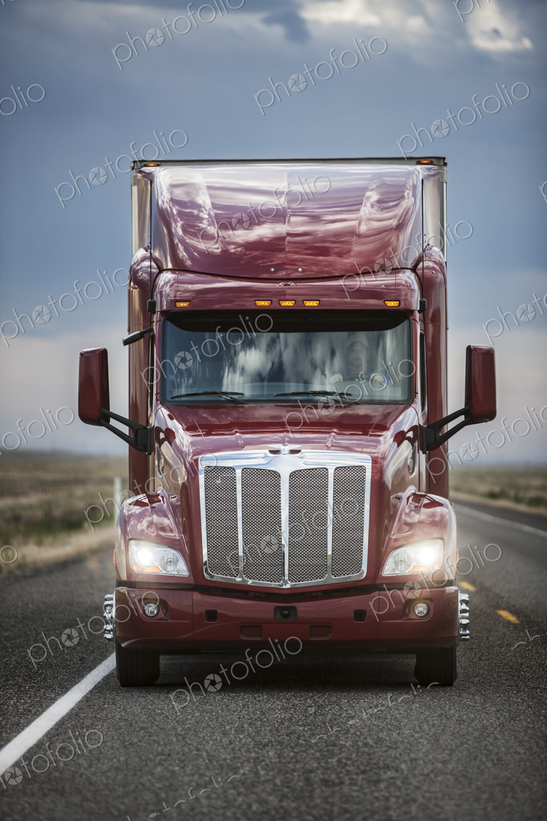 Front view of the cab of a commercial truck on the highway.