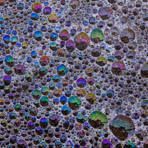 Froth and bubbles of air reflecting rainbow colours on the surface at Cannon Beach,… Froth and bubbles of air reflecting rainbow colours on the surface at Cannon Beach,…