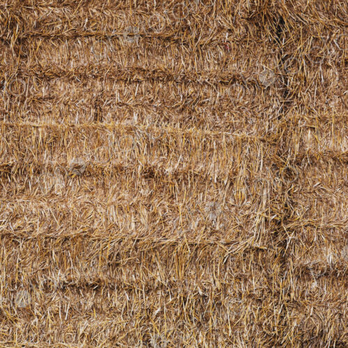 Full frame close up of neatly stacked straw bales.