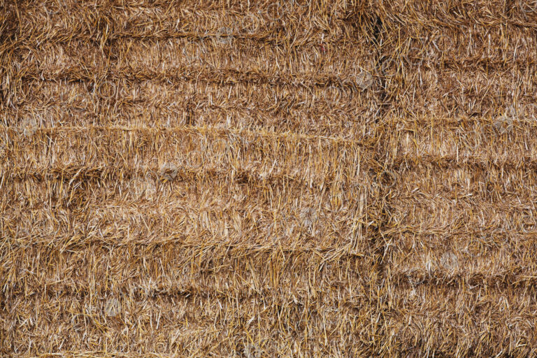Full frame close up of neatly stacked straw bales.