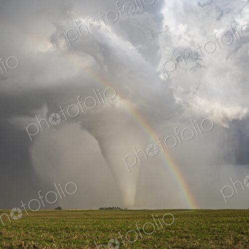 Fully Condensed Tornado with a Rainbow, a spiralling column of air reaching the ground. Fully Condensed Tornado with a Rainbow, a spiralling column of air reaching the ground.