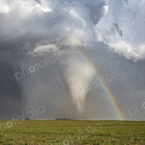 Fully Condensed Tornado with a Rainbow, a spiralling column of air reaching the ground. Fully Condensed Tornado with a Rainbow, a spiralling column of air reaching the ground.