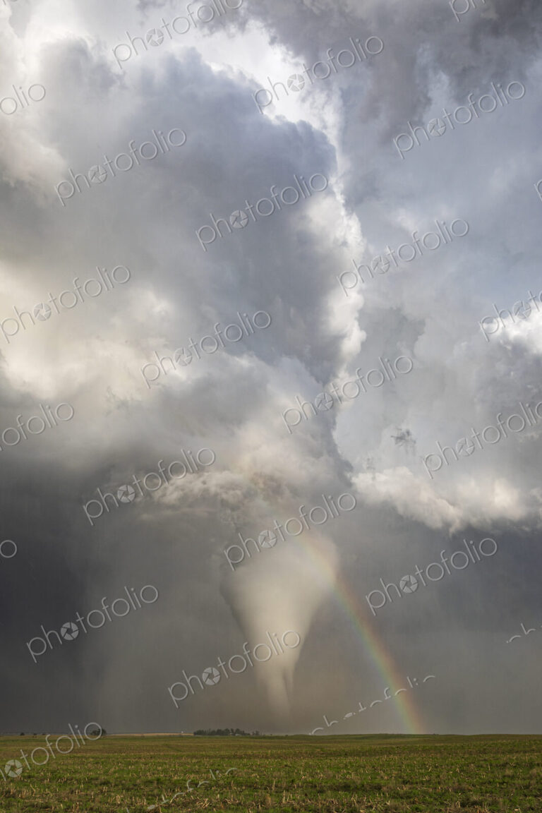 Fully Condensed Tornado with a Rainbow, a spiralling column of air reaching the ground.