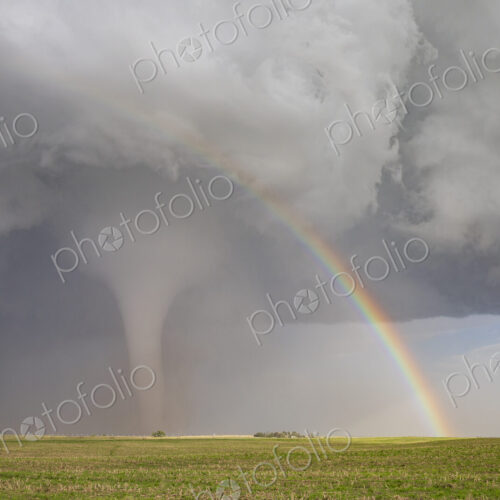 Fully Condensed Tornado with a Rainbow. a rotating column of air reaching the ground. Fully Condensed Tornado with a Rainbow. a rotating column of air reaching the ground.