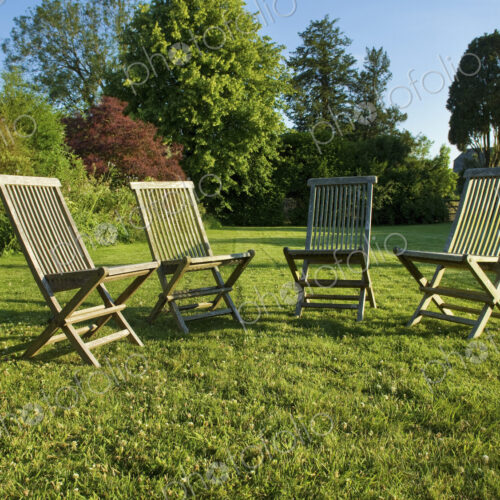 Garden chairs placed grouped on a lawn in Gloucestershire in summer. Garden chairs placed grouped on a lawn in Gloucestershire in summer.