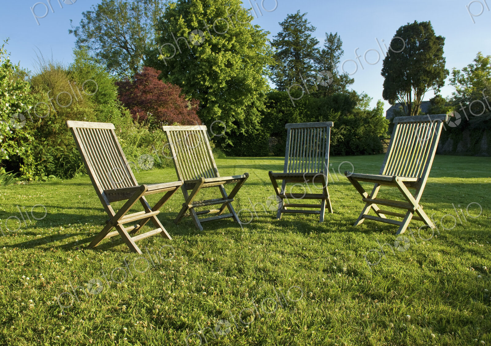 Garden chairs placed grouped on a lawn in Gloucestershire in summer.