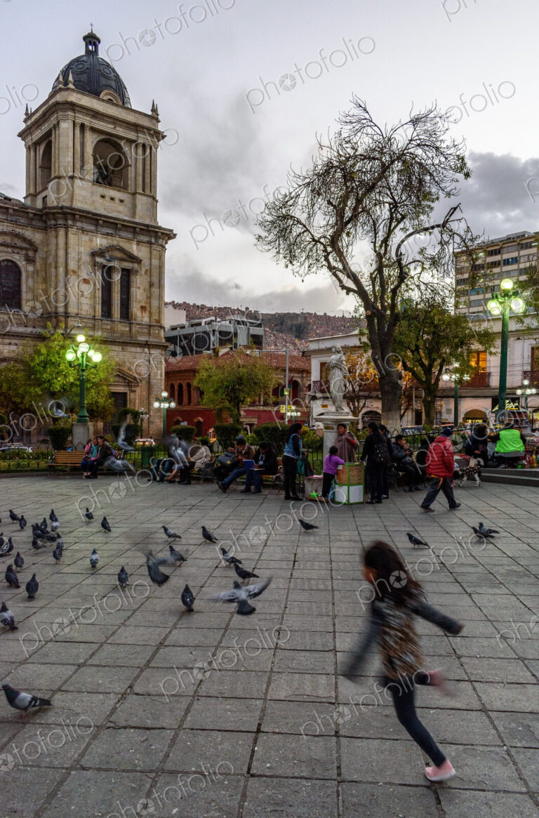 Girl chasing pigeons in Plaza Murillo, the central plaza of La Paz, Bolivia.
