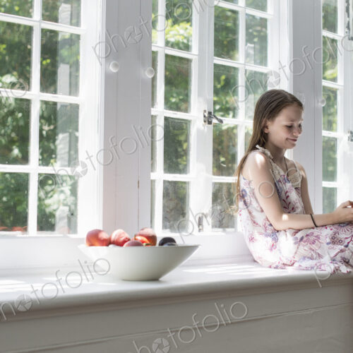Girl sitting by a window. Girl sitting by a window.