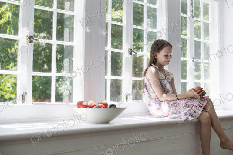 Girl sitting by a window.