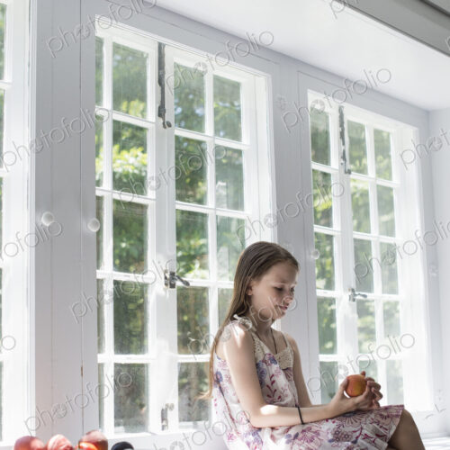 Girl sitting by a window. Girl sitting by a window.