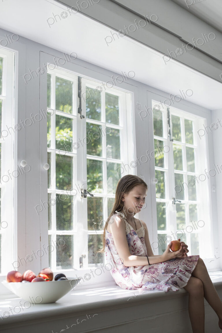Girl sitting by a window.