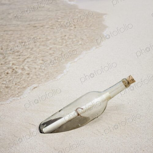 Glass bottle with rolled note washed up on beach in Isla Mujeres, Symbolic image…