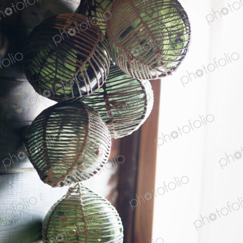 Glass fishing floats handing in a cluster on a wall. Glass fishing floats handing in a cluster on a wall.