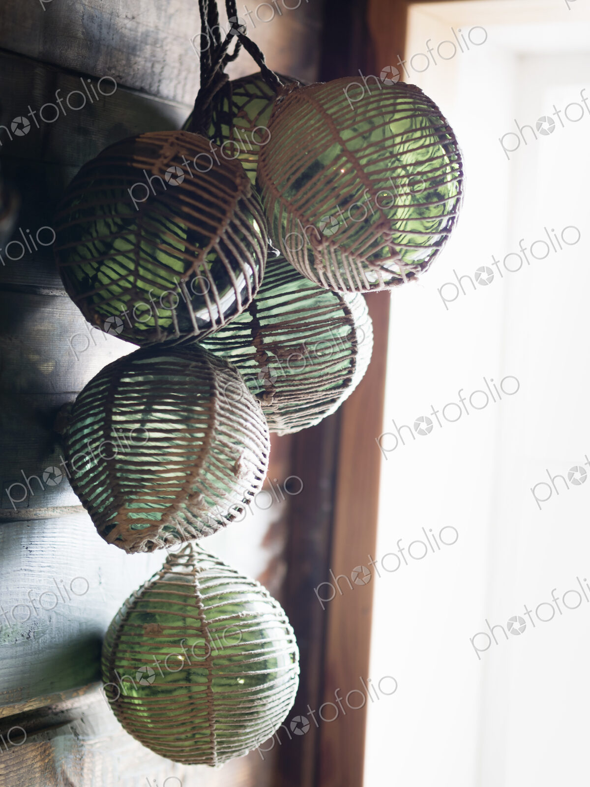 Glass fishing floats handing in a cluster on a wall.