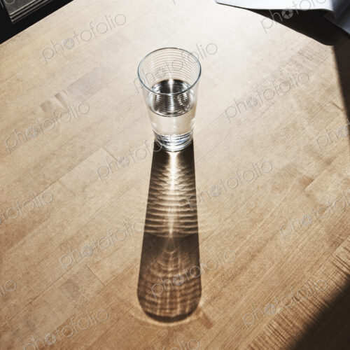 Glass of drinking water on wooden surface.