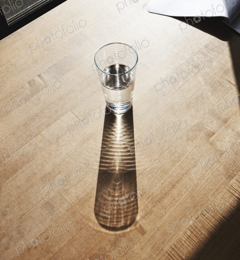 Glass of drinking water on wooden surface.