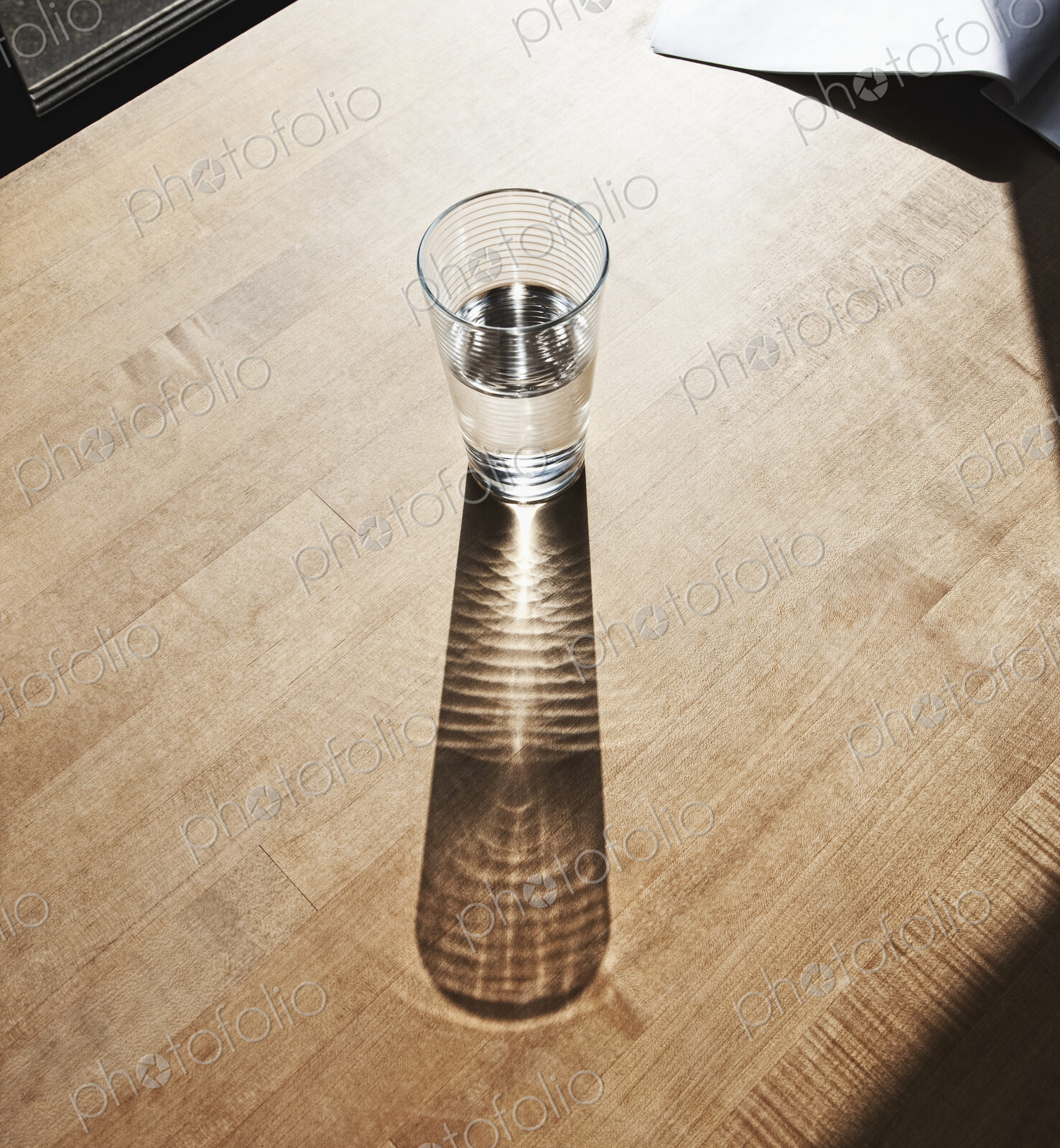 Glass of drinking water on wooden surface.