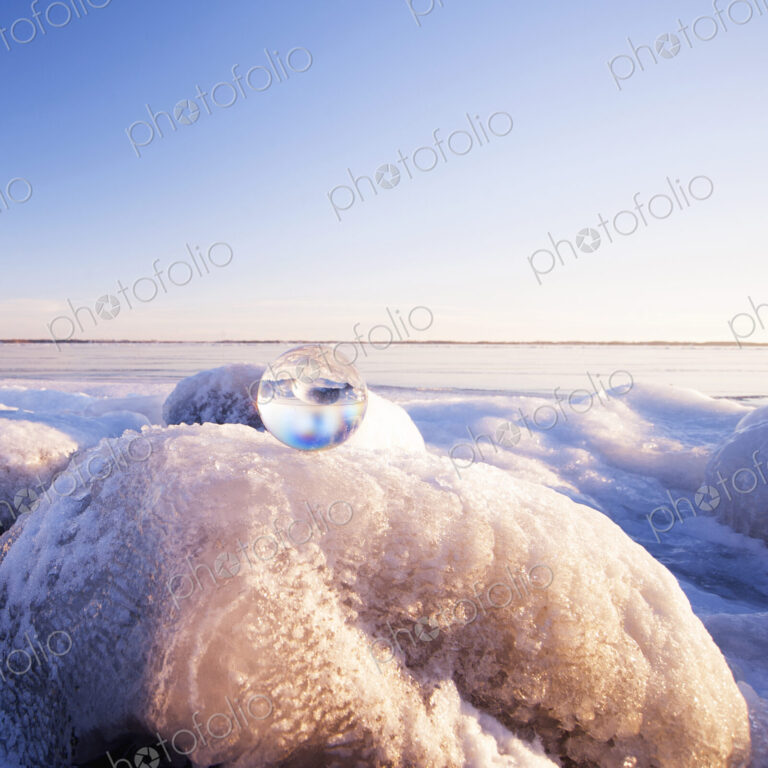 Glass sphere on frozen rock formations