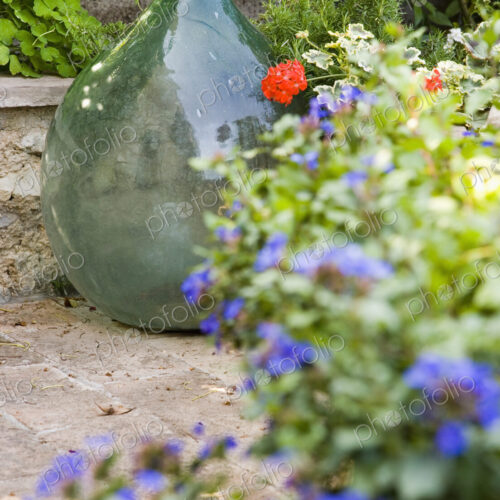Glass vase with flower pots on terrace in garden. Glass vase with flower pots on terrace in garden.