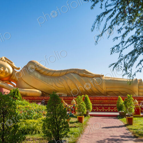 Golden Reclining Buddha in gardens at Wat Pha That Luang Vientiane Laos Golden Reclining Buddha in gardens at Wat Pha That Luang Vientiane Laos