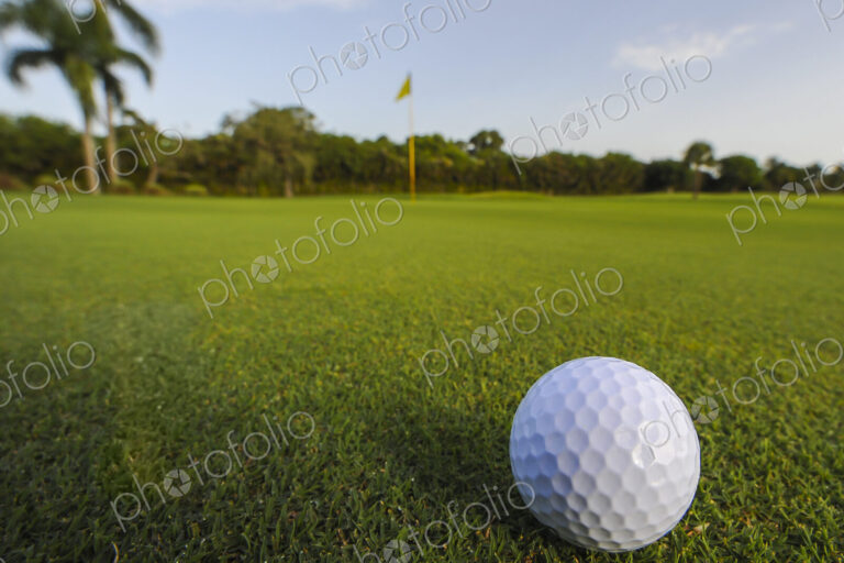 Golf ball rolling on putting green