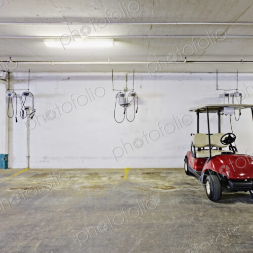 Golf buggy in a parking lot.