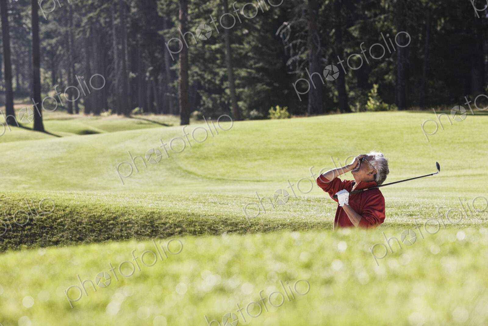 Golfer reacting with frustration at a missed shot from a bunker near the green on a…