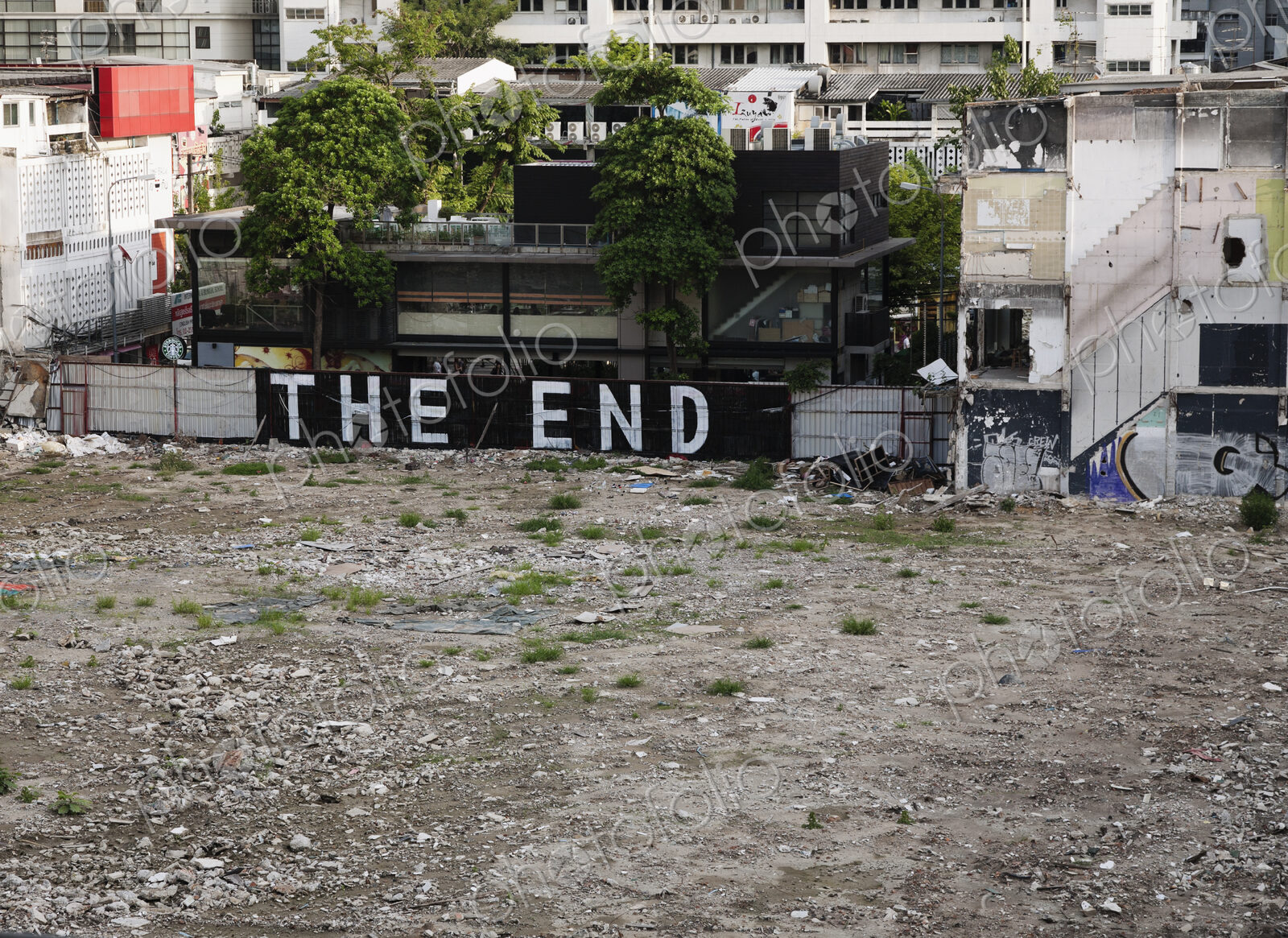 Graffiti that reads “THE END” in an empty lot, urban scene overlooking wasteland in…