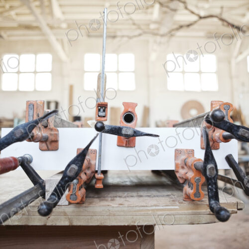 Graphic pattern of clamps used to glue a part together in a woodworking factory.