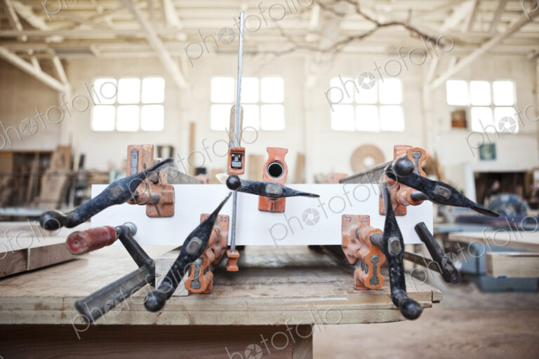 Graphic pattern of clamps used to glue a part together in a woodworking factory.