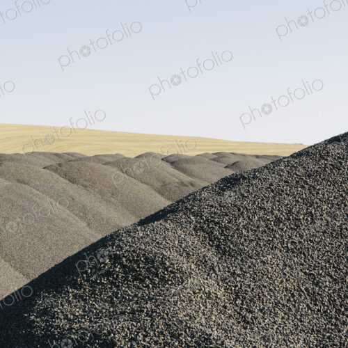 Gravel piles used for road maintenance and construction, a row of heaps near Pullman,…