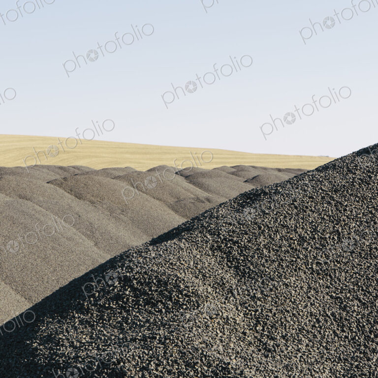 Gravel piles used for road maintenance and construction, a row of heaps near Pullman,…