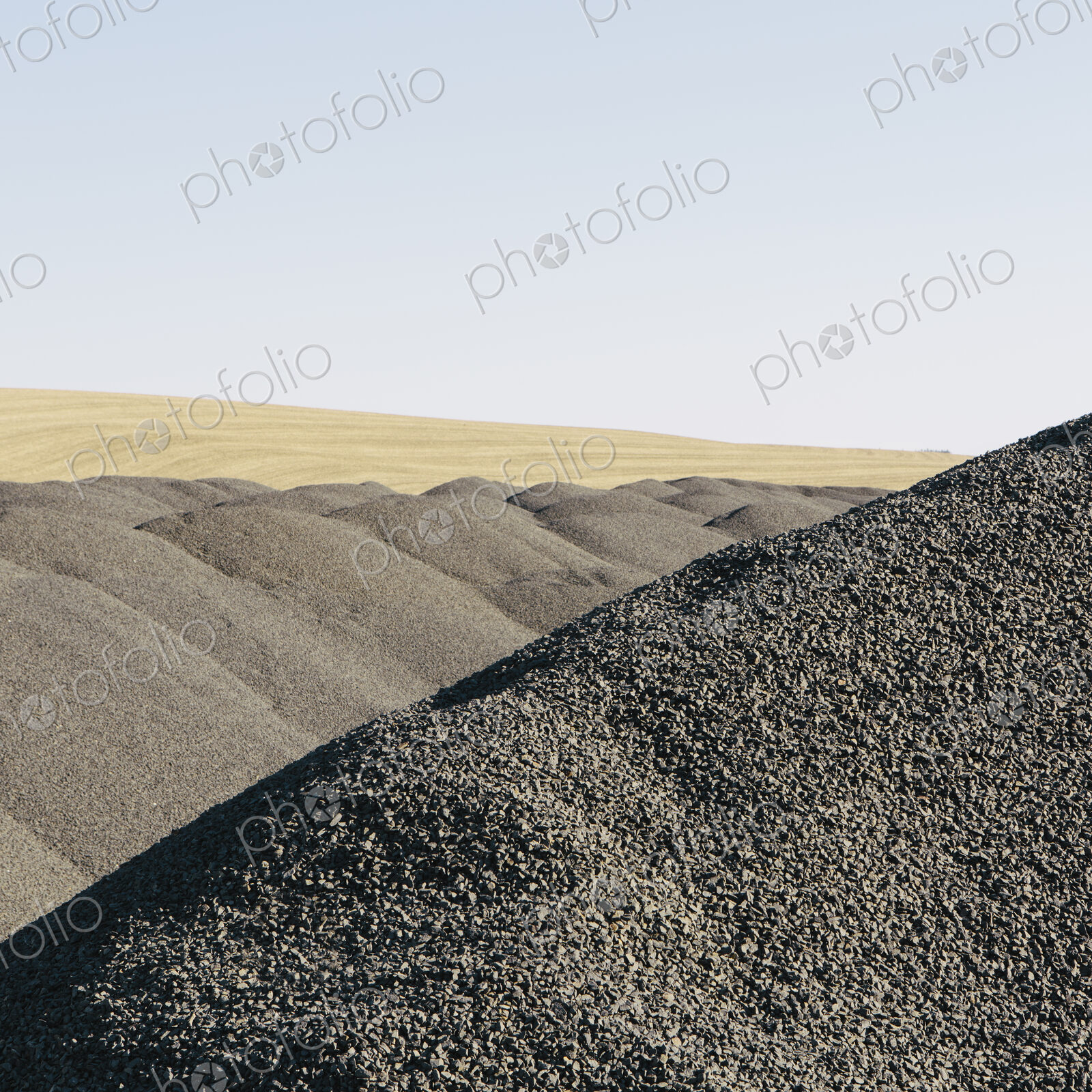 Gravel piles used for road maintenance and construction, a row of heaps near Pullman,…