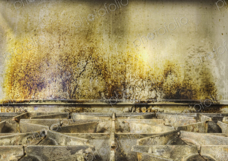 Greasy gas stove top in old catering kitchen.
