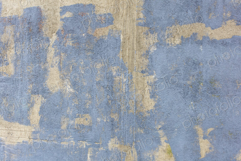 Grey paint covering graffiti tags on concrete wall