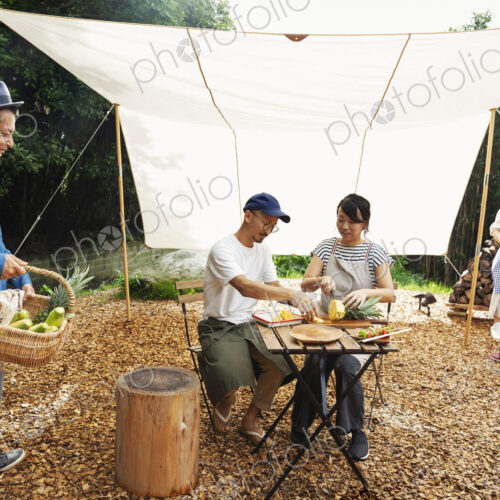 Group of Japanese men and women and boy gathered around a table under a canopy,… Group of Japanese men and women and boy gathered around a table under a canopy,…