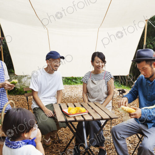 Group of Japanese men and women and boy gathered around a table under a canopy,… Group of Japanese men and women and boy gathered around a table under a canopy,…