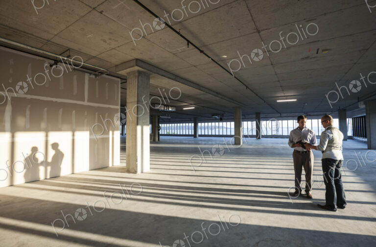 Group of business people looking at a new empty raw office space.