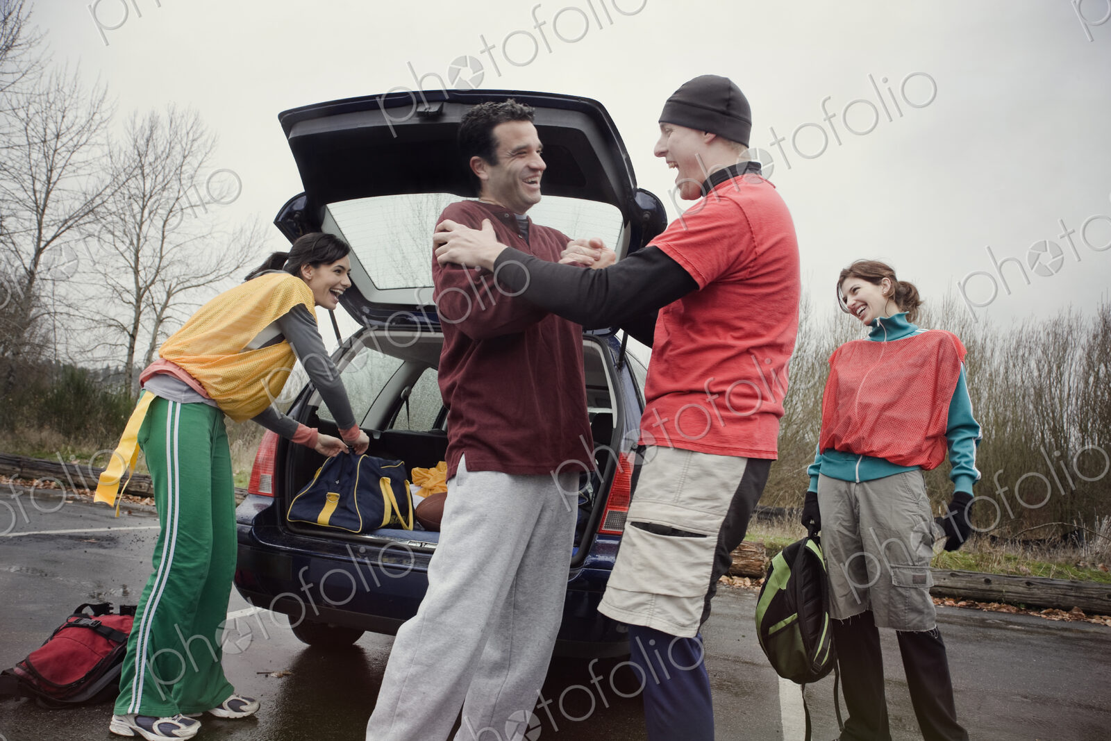 Group of friends unloading gear from a car prior to an American Flag Football game.