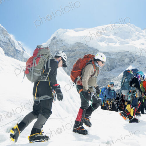 Group of hikers backpacking on snowy mountain path Group of hikers backpacking on snowy mountain path