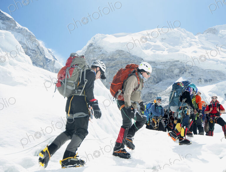 Group of hikers backpacking on snowy mountain path