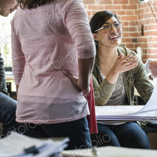 Group of men and women at work at a conference table.