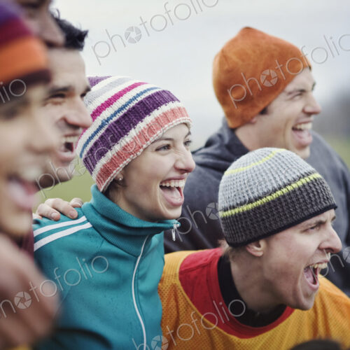 Group of men and women friends cheering at an informal sporting event in winter. Group of men and women friends cheering at an informal sporting event in winter.