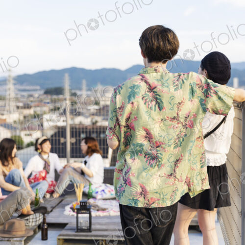 Group of young Japanese men and women on a rooftop in an urban setting. Group of young Japanese men and women on a rooftop in an urban setting.