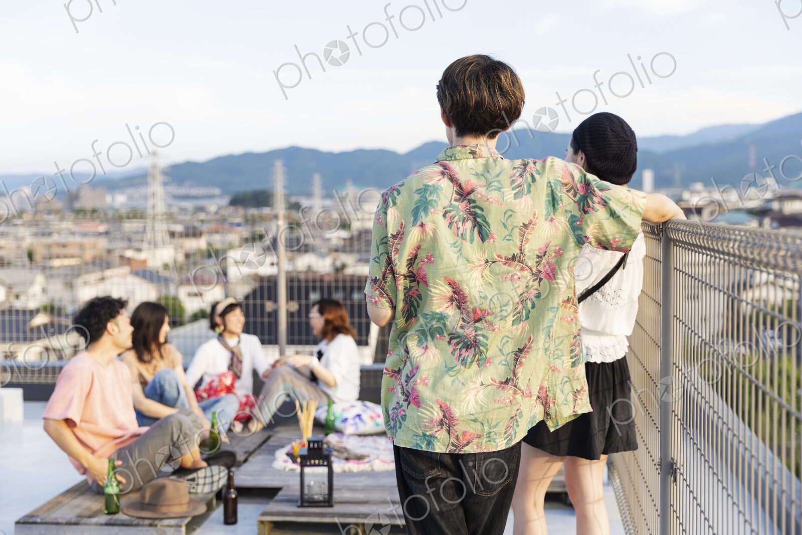 Group of young Japanese men and women on a rooftop in an urban setting.