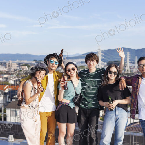 Group of young Japanese men and women standing on a rooftop in an urban setting. Group of young Japanese men and women standing on a rooftop in an urban setting.