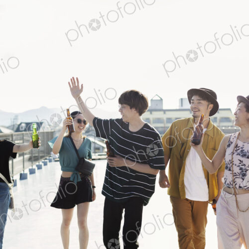Group of young Japanese men and women standing on a rooftop in an urban setting. Group of young Japanese men and women standing on a rooftop in an urban setting.