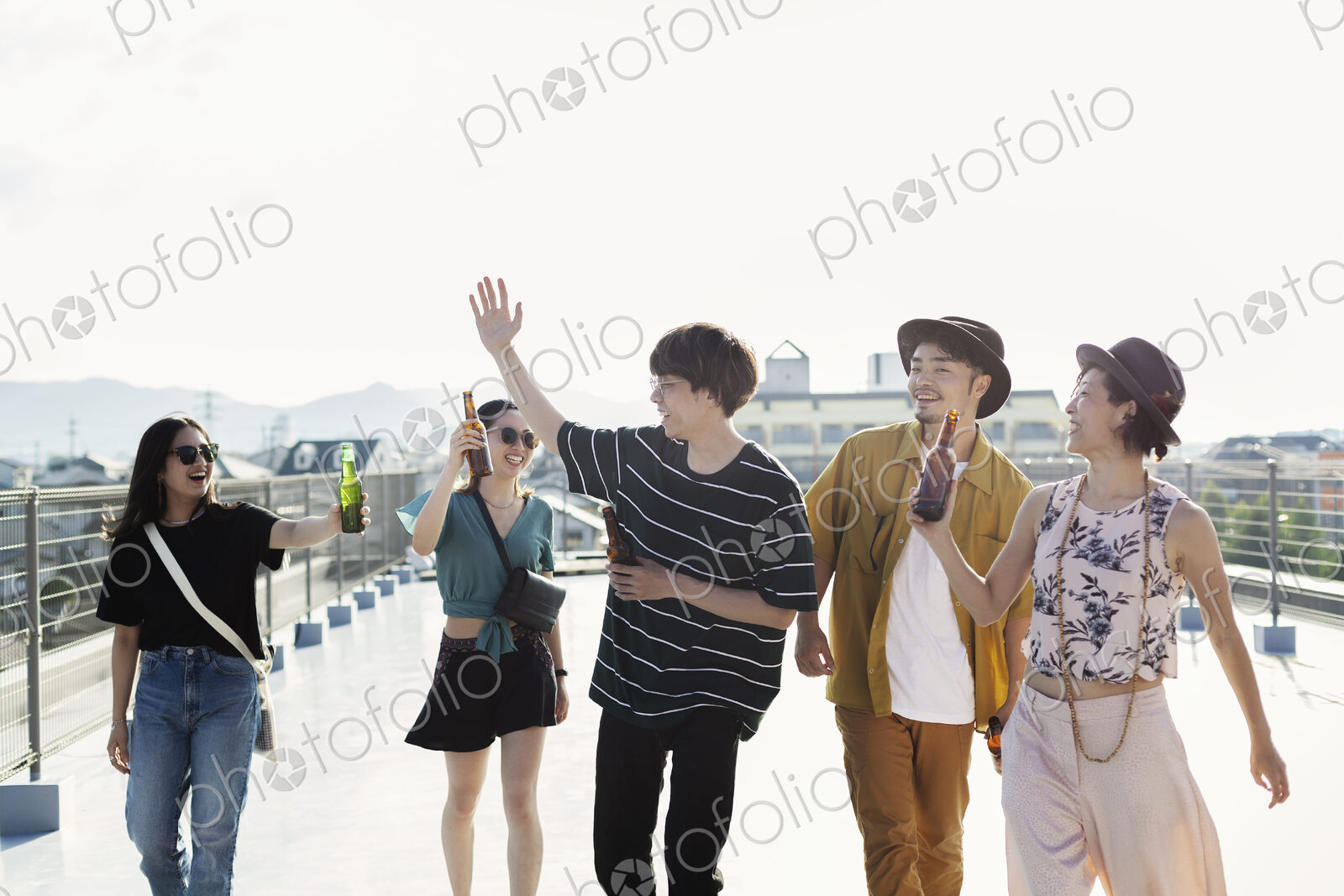 Group of young Japanese men and women standing on a rooftop in an urban setting.