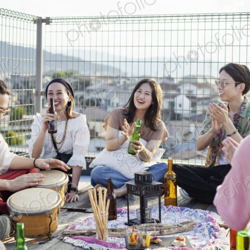 Group of young Japanese men and women standing on a rooftop in an urban setting. Group of young Japanese men and women standing on a rooftop in an urban setting.